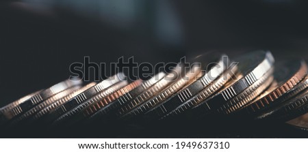 Close up of row of coins on dark background for business and finance concept, wide screen, plenty of copy space Royalty-Free Stock Photo #1949637310