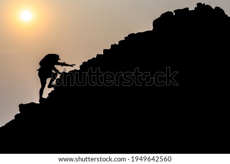 Young male tourists climbing mountains Ideas for personal development and goals in the life of a climber with a backpack. Royalty-Free Stock Photo #1949642560
