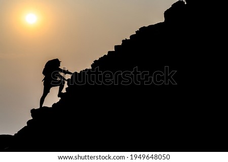 Young male tourists climbing mountains Ideas for personal development and goals in the life of a climber with a backpack. Royalty-Free Stock Photo #1949648050