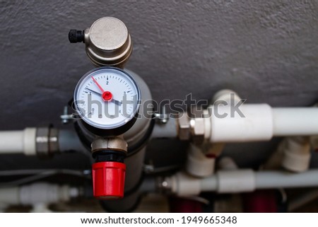A device for measuring the temperature of water in the heating system. Pipe pressure relief valve. Royalty-Free Stock Photo #1949665348