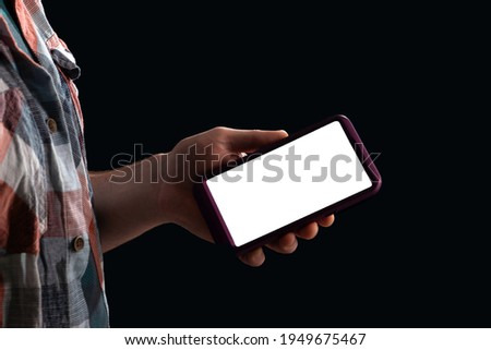 Mobile phone in the hand of a teenager, mocap copy space, hand in the shade