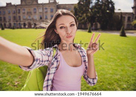 Photo of young attractive woman make selfie cellphone pouted lips send air kiss show peace cool v-sign travel park outdoors