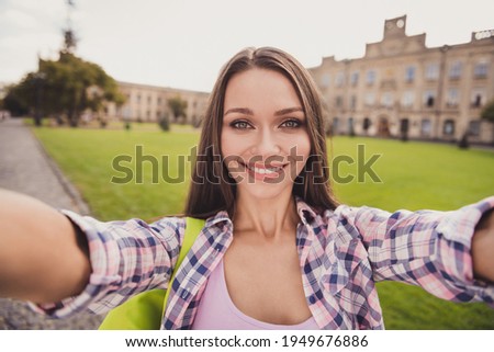 Photo of charming beautiful young student girl make camera selfie positive smile outside in university outdoors