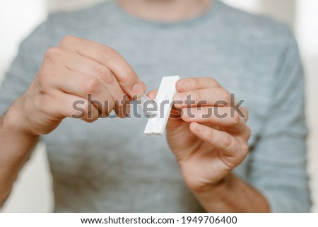 Lateral-Flow-Test covid rapid home-use test kit for saliva - step 4 - transfer three drops of liquid sample to Test cassette Royalty-Free Stock Photo #1949706400