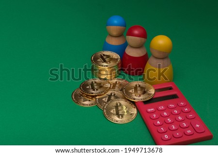 Stack of golden bitcoins with decorations (wooden peg dolls and red calculator), on dark green background. A selective focus photo of bitcoins.