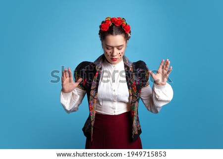 young woman in the image of the Mexican artist Frida with red roses in her hair.