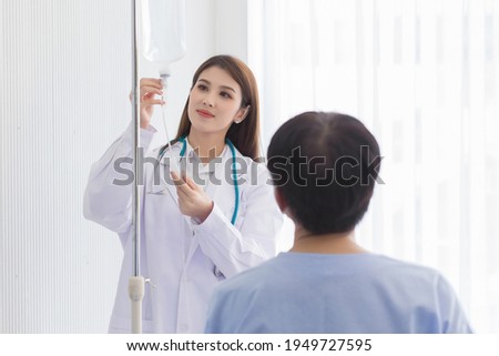 Asian female doctor looking at a drop of saline solution for patients in health care and coronavirus protection concept.