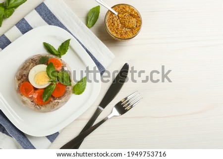 Delicious aspic with meat served on white wooden table, flat lay. Space for text
