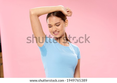 woman in blue t-shirt sweaty armpits foul odor Royalty-Free Stock Photo #1949765389