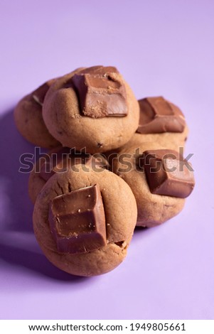 chocolate brown cookies with kinder chocolate in top on purple background 