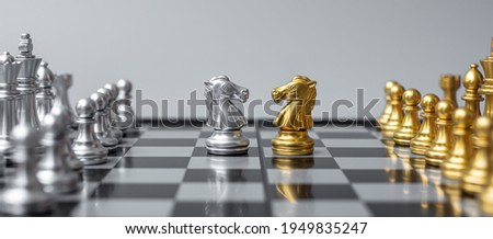 Gold and silver Chess Knight (horse) figure on Chessboard against opponent or enemy. Strategy, Conflict, management, business planning, tactic, politic, communication and leader concept Royalty-Free Stock Photo #1949835247