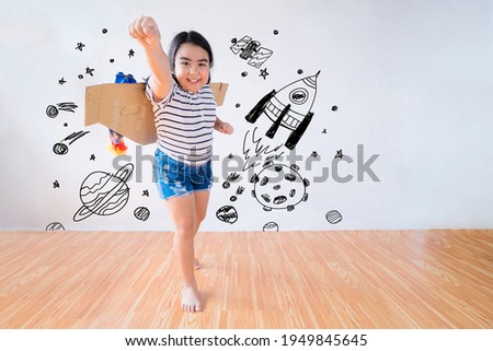 Child plays in an astronaut costume and dreams of becoming a spaceman. The background is a wall with a picture of a country.