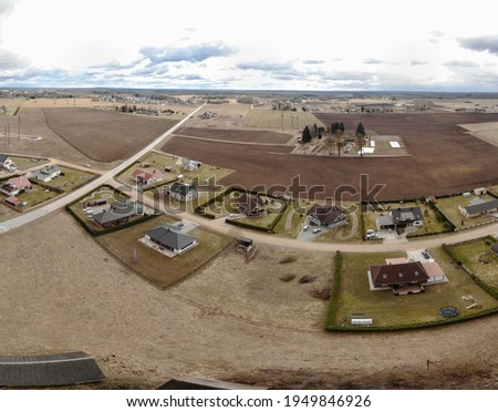 Drone photo of new realestate region located near Tartu city. Räni village filled with new buildings. New modern region built between the old farming fields. Agricultural land is filled with buildings