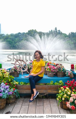 Asian woman posing in beautiful park behind Senayan Park Mall Jakarta, Indonesia where people go and take their own pictures