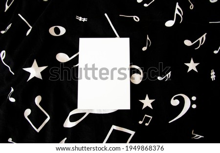 Greeting card, postcard, invitation, blank paper mock up on black background with musical notes. Flat. lay.
