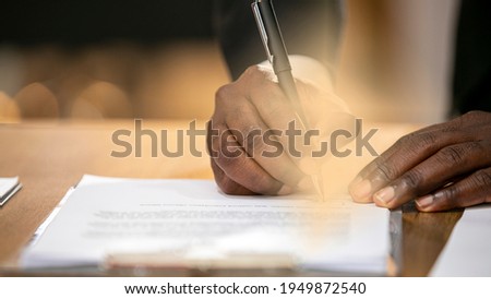 Portrait of hand signing a contract.