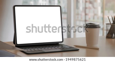 Close-up view of open blank screen laptop computer with office supplies in modern office

