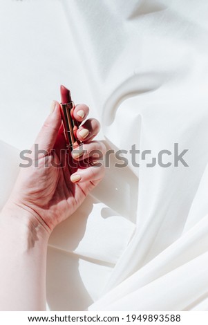 Red lipstick on a silk white  background, luxury and minimalism feeling for Instagram marketing or fashion 