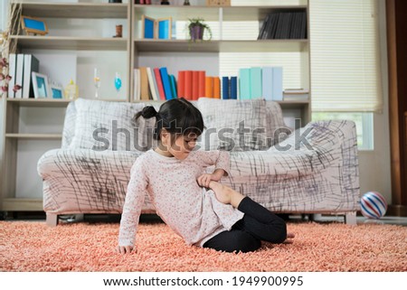 Cute little girl practicing yoga on the carpet in the living room