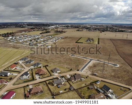 Drone photo of new realestate region located near Tartu city. Räni village filled with new buildings. New modern region built between the old farming fields. Agricultural land is filled with buildings