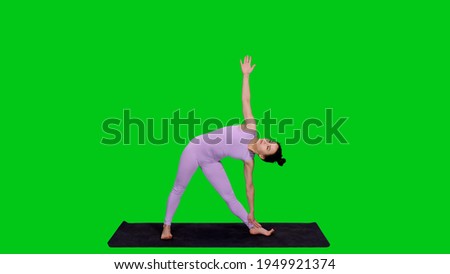 Young beautiful woman in bodysuit doing triangle pose practicing yoga on green screen background