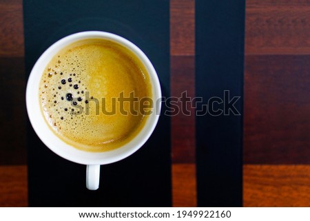 Close up a cup of black aroma coffee with space for text on wooden table at home. Top view image.                                        