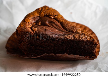 Brownie cake topped with juicy chocolate sauce on a white paper background.
