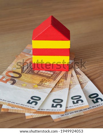colored house made of wooden cubes on euro banknotes with a wooden background
