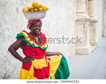 Traditional fresh fruit street vendor aka Palenquera in the Old Town of Cartagena in Cartagena de Indias, Caribbean Coast Region, Colombia. Royalty-Free Stock Photo #1949940745