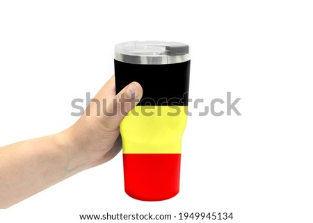 A hand holds a sports water bottle with the flag of Belgium on the bottle and isolated on a white background. Healthy lifestyle concept.