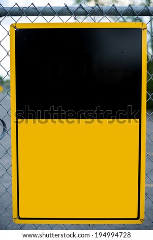 A blank caution or warning type notice sign affixed to a chain-link fence - ready for your text