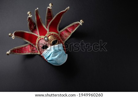 Carnival masks in protecting masks. Conceptual image of the theme of the virus. Copy space.