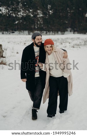 stylish couple walking in a snow field