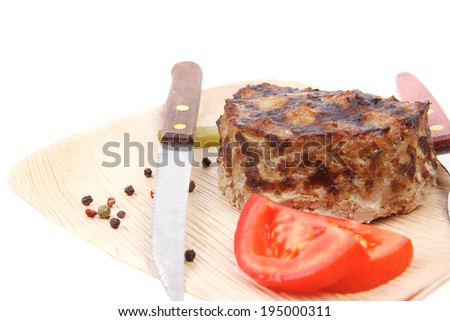 extra thick hot beef meat hamburger lunch on light wooden plate with tomatoes salad and cutlery isolated on white background