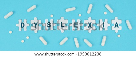 Medicine and health. On a blue background, there are pills and puzzles with the inscription - DYSLEXIA