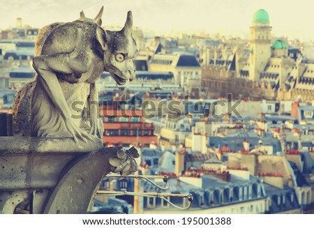 Gargoyle of Notre Dame Cathedral with roof of Paris on a background. Vintage picture