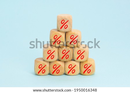 Percent sign on wooden cubes against blue background . Concept of sale and discount.