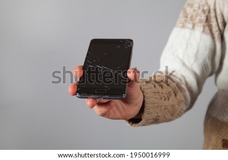 Broken phone in the hand of a caucasian boy.