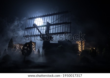 Silhouettes of satellite dishes or radio antennas against night sky. Space observatory or Air defence radar over dramatic night sky. Creative artwork decoration. Selective focus