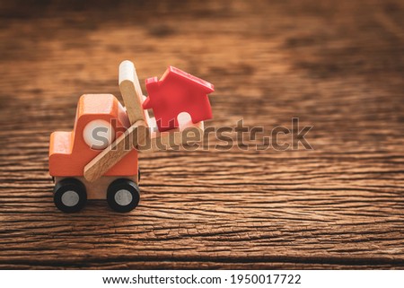 Transport red house model for build a new house on old wood background, saving money and loan for construction real estate and family home concept.
