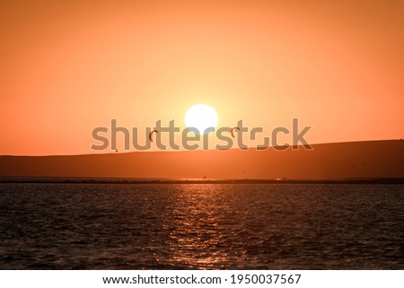 Kite surfing on sunset background