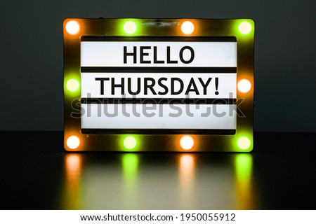 Lightbox with yellow and orange lights in dark room with words - Hello Thursday!