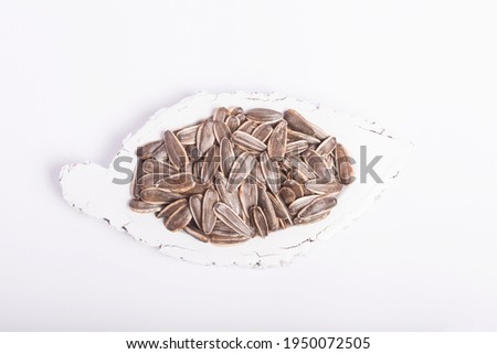 black sunflower seeds, dakota on the ground and in the bowl on a white background
