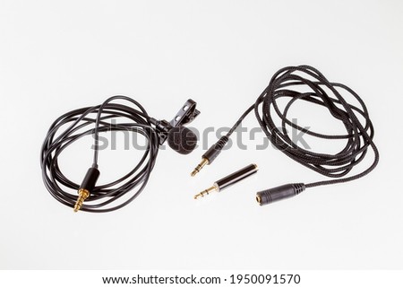 Small lavalier microphone or lapel mic with clip, adapter and extension cable for computer.Professional sound recording equipment for cell phone.