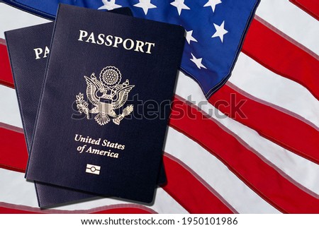 US American Passports acquisition after immigration citizenship exam over an American flag background.  Royalty-Free Stock Photo #1950101986