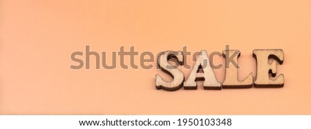 Discount sale. Large letters sale, action. Wooden letters discount on orange background.