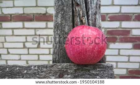 A red apple lying on a dark gray board.