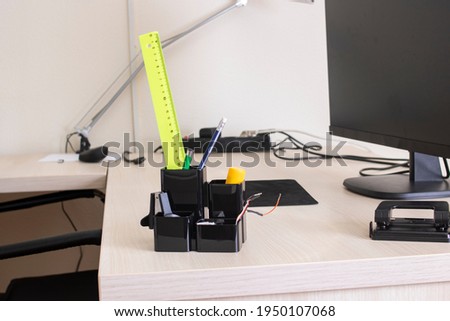 Stationery stand with pens and pencils on desktop close up