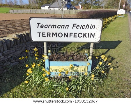 Roadside sign for Termonfeckin village or Tearmann Feichin in the Irish language, in County Louth, Ireland.  Royalty-Free Stock Photo #1950132067