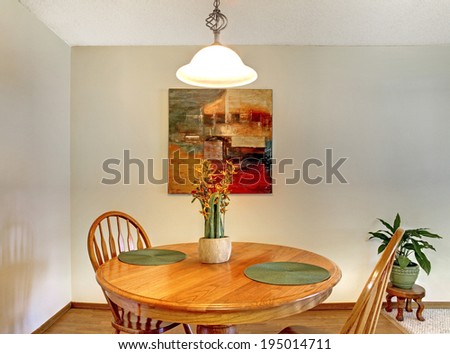 Dining area with rustic dining table set decorated with flowers and picture on the wall